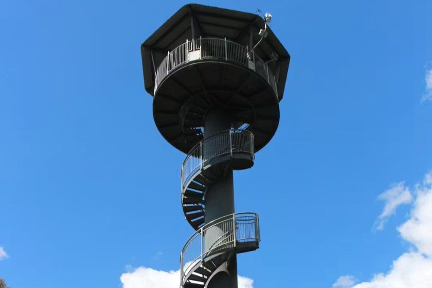 나선형 계단이 있는 높은 전망대와 맑고 푸른 하늘을 배경으로 한 육각형 전망대가 있습니다.