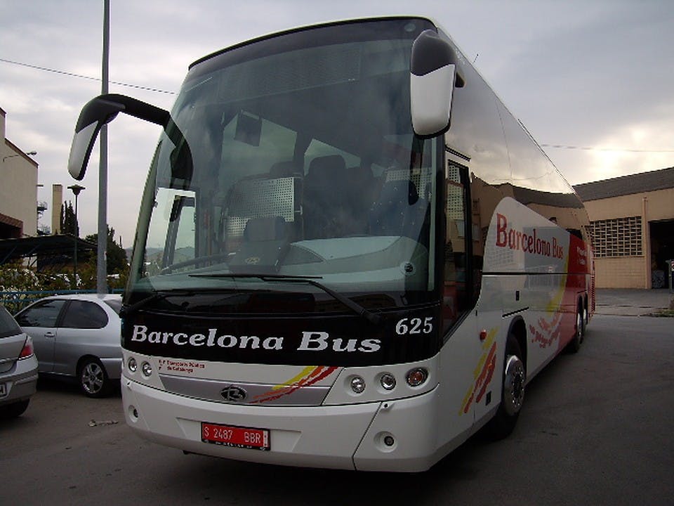 '바르셀로나 버스' 라고 표시된 흰색 버스 앞면의 625번이 흐린 하늘 아래 거리에 주차되어 있습니다.