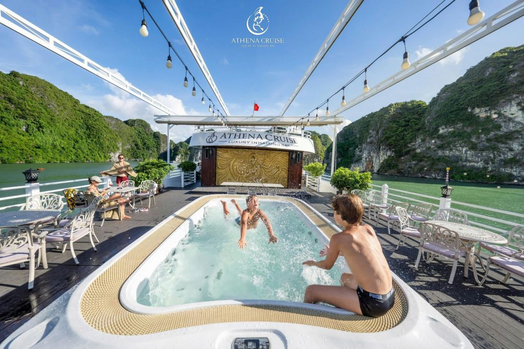 맑고 푸른 하늘 아래 절경을 배경으로 고급 유람선 데크에서 작은 수영장을 즐기는 두 사람.