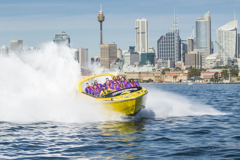 탑을 포함한 도시의 스카이라인을 배경으로 노란색 스피드보트가 물가에서 커다란 풍경을 연출합니다.