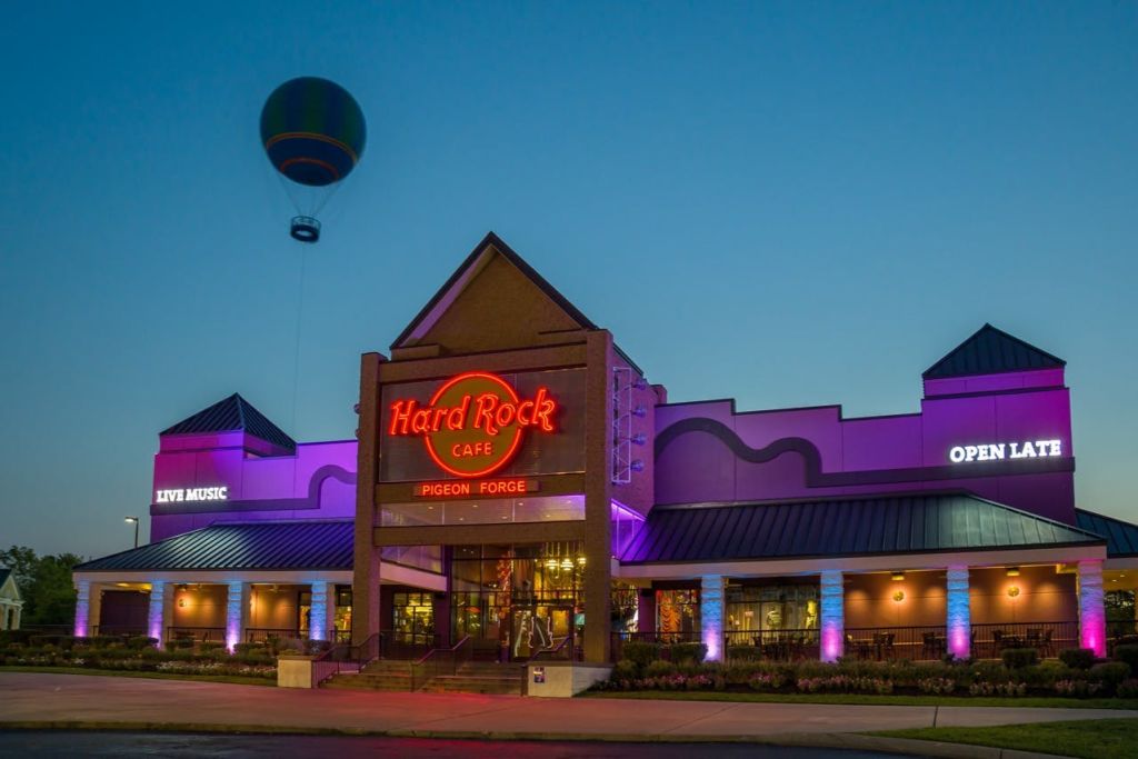 해질 무렵의 하드록 카페 비둘기 포지 (Hard Rock Cafe Pigeon Forge) 의 외관, 네온사인과 하늘의 열기구.