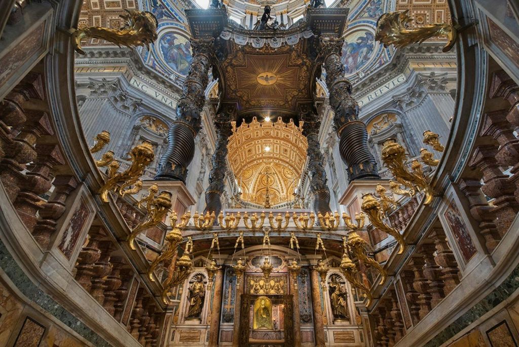 화려한 금색 디테일, 높은 기둥, 장식용 돔 천장이 특징인 대성당의 정교한 내부.