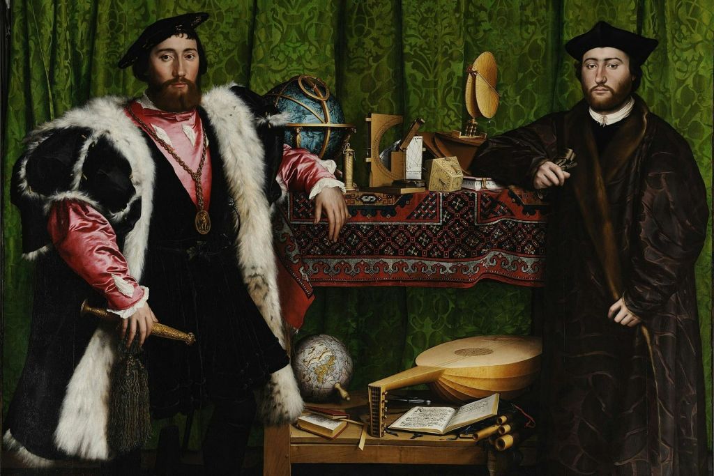 16세기 복장을 한 두 남자가 초록색 무늬의 커튼을 배경으로 과학 기구와 책이 놓인 탁자 옆에 서 있습니다.