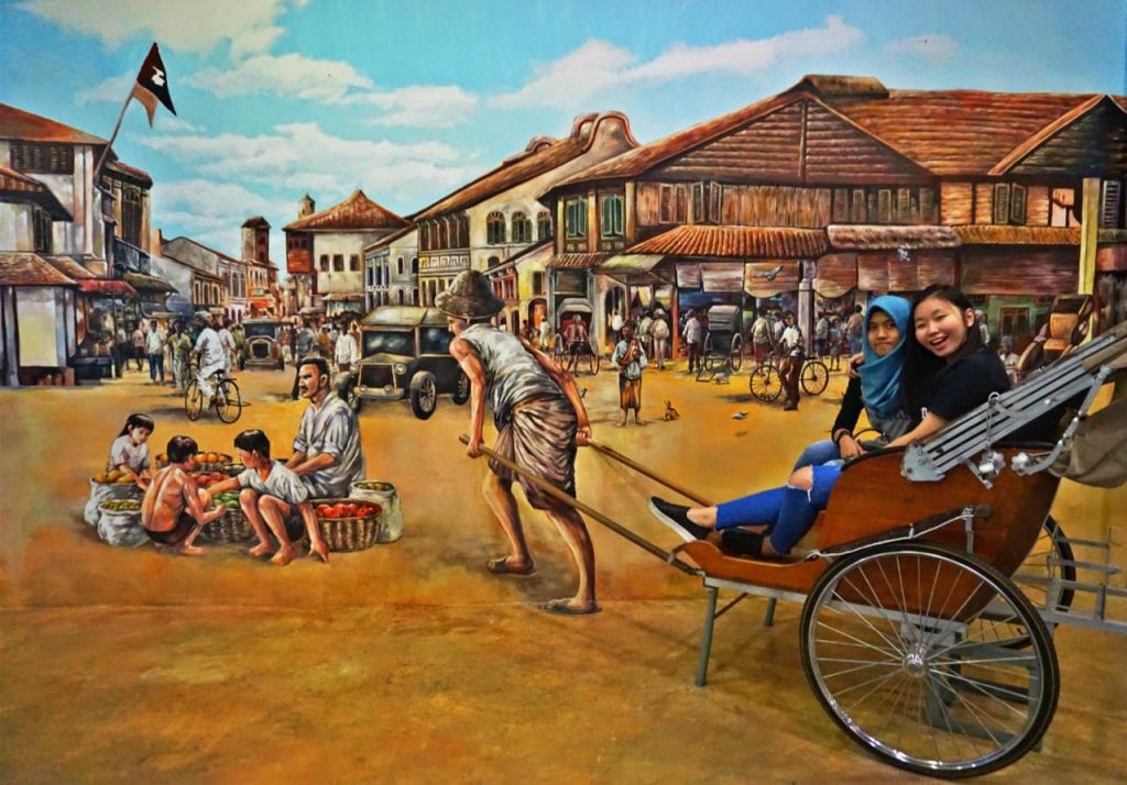 건물과 사람이 즐비한 번잡한 역사적인 거리의 벽화와 맞닿아 있는 인력거에 두 명의 여성이 앉아 있습니다.