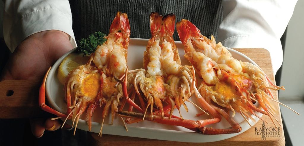 흰 접시에 파슬리를 장식한 바닷가재 구이 세 마리.