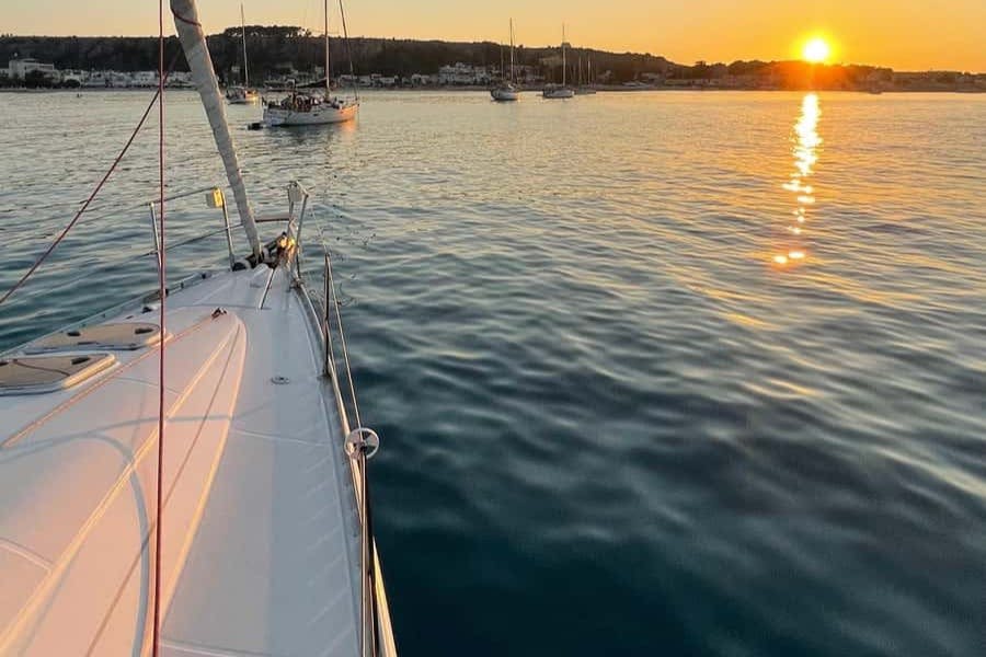 잔잔한 바다가 내려다보이는 돛단배의 갑판에서 바라보는 풍경과 멀리 다른 여러 보트와 수평선에 지는 석양을 감상할 수 있습니다.