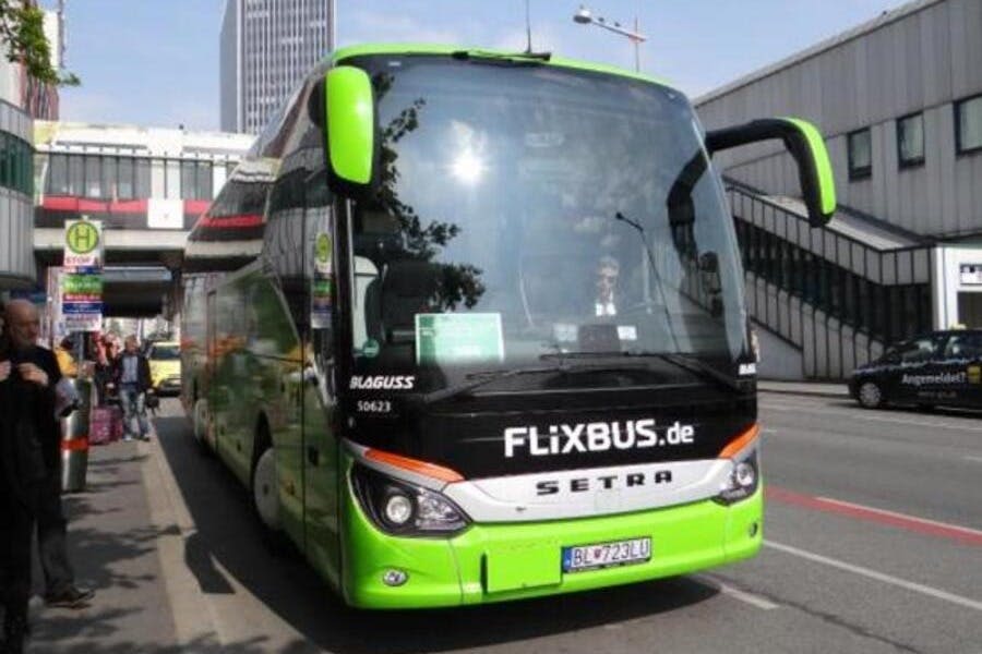 녹색 FlixBus 코치가 거리에 주차되어 있습니다. 운전자는 건물이 배경인 앞유리를 통해 볼 수 있습니다.