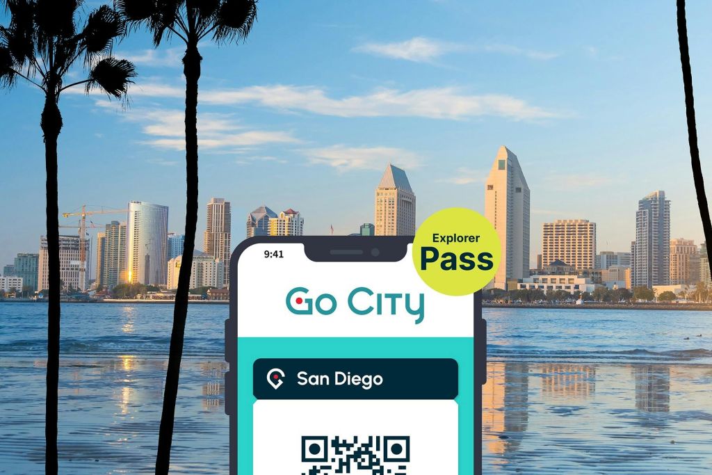 샌디에이고 익스플로러 패스 바이 고 시티 (San Diego Explorer Pass by Go City) 는 도시의 스카이라인과 항구를 배경으로 한 스마트폰에 전시되어 있습니다.