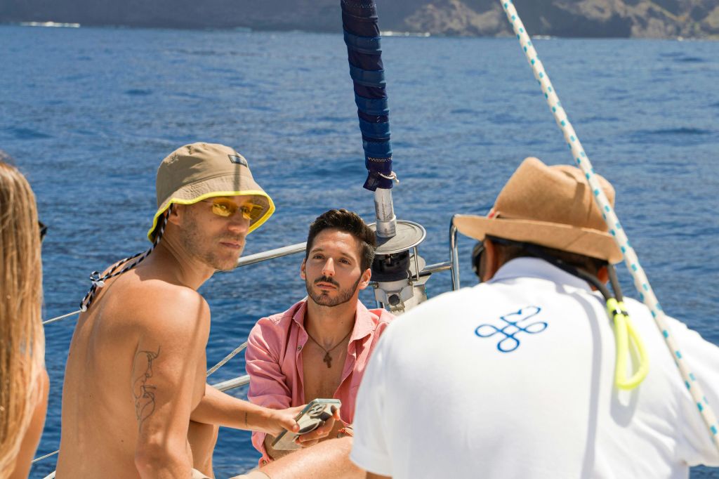 Amigos disfrutando en el barco, hablando con el capitán