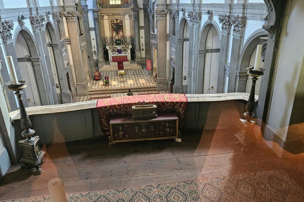 발코니에서 붉은 천, 장식 요소, 건축 디테일이 있는 제단이 있는 화려한 교회 내부의 전망.