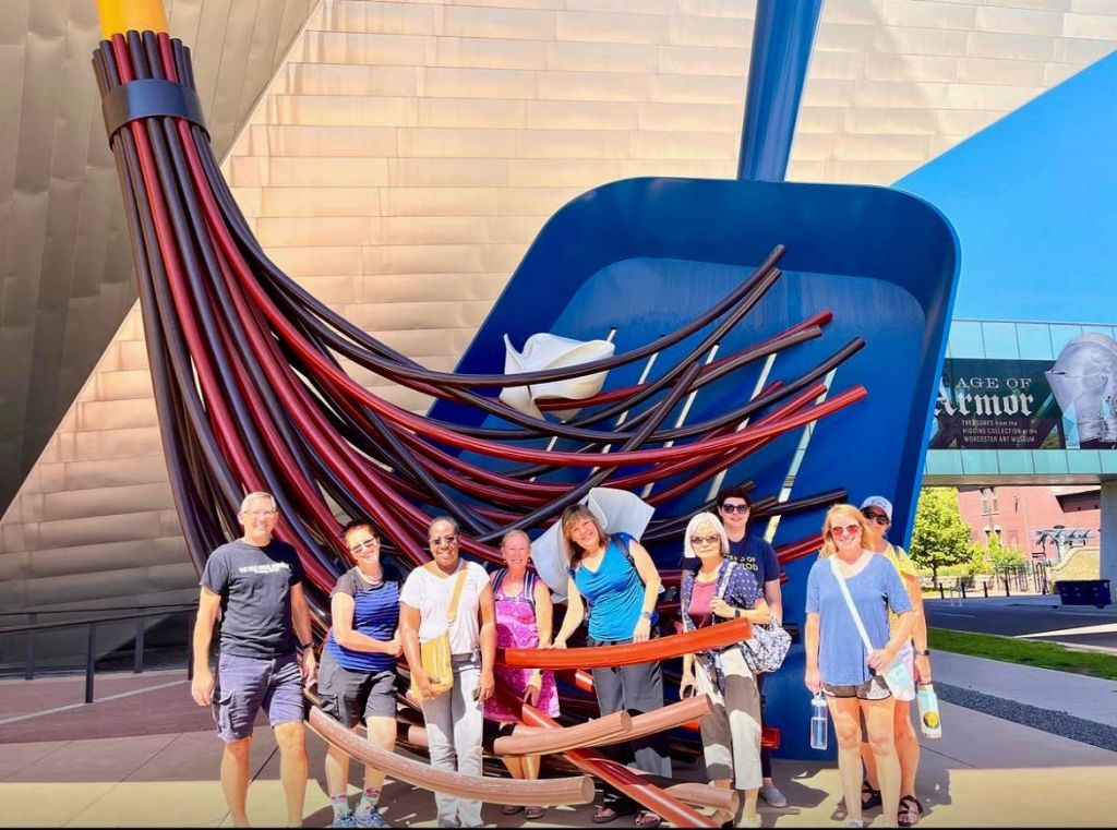 대형 붓모를 닮은 커다란 조각상 앞에서 포즈를 취하고 있는 한 무리의 사람들.