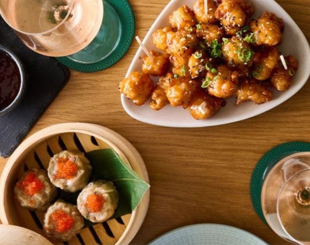 새우 튀김, 노루와 함께 찐 만두, 나무 테이블에 놓인 음료.