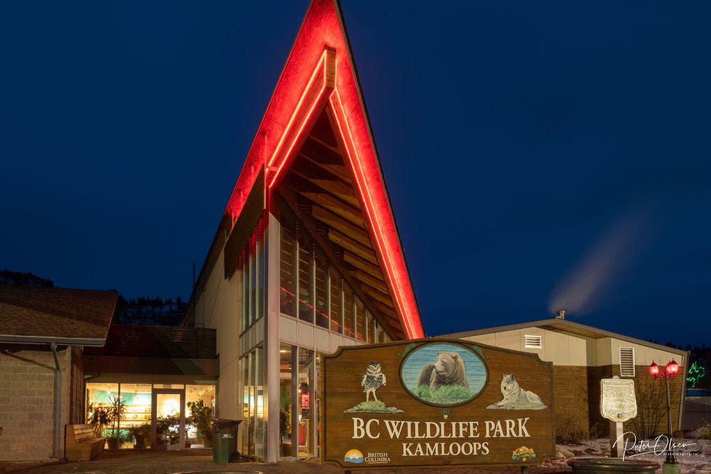 높이 솟은 지붕에 빨간불이 켜져 있고, 정면에 'BC Wildlife Park Kamloops' 라는 표지판이 있습니다.