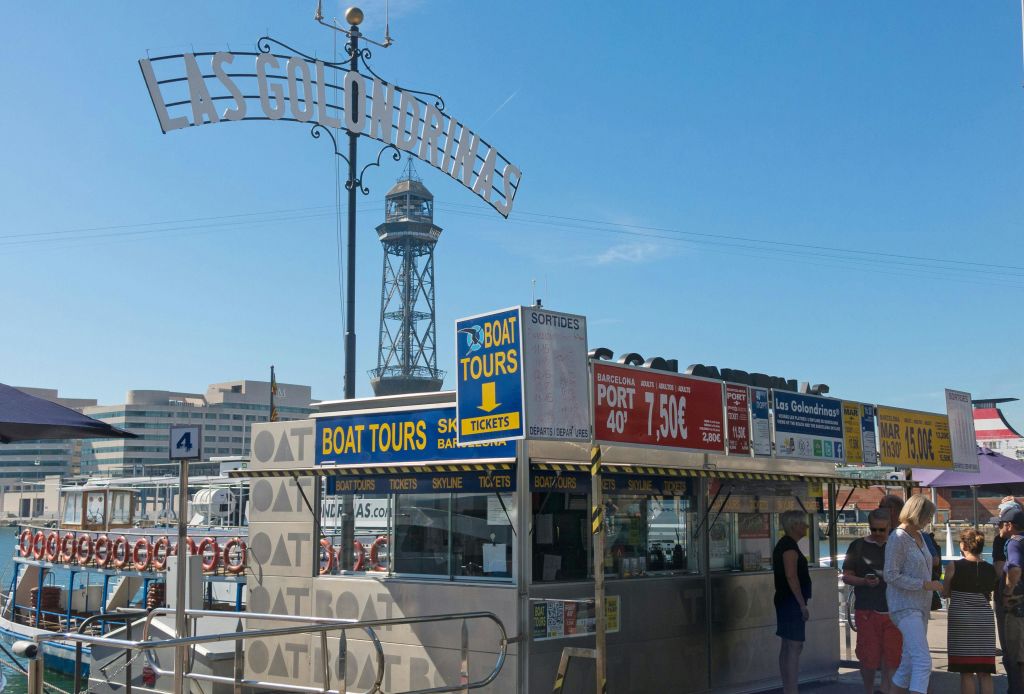 높은 타워와 다른 건물을 배경으로 "Las Golondrinas" 라고 적힌 표지판 아래 보트 투어를 위한 티켓 부스가 있습니다.
