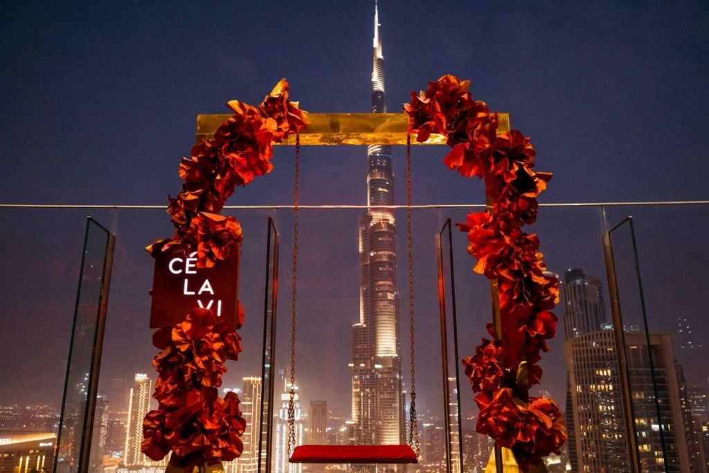 밤에는 부르즈 할리파 (Burj Khalifa) 앞에 붉은 꽃으로 장식된 그네입니다. 왼쪽의 표지판에는 "CE LA VI" 라고 쓰여 있습니다.