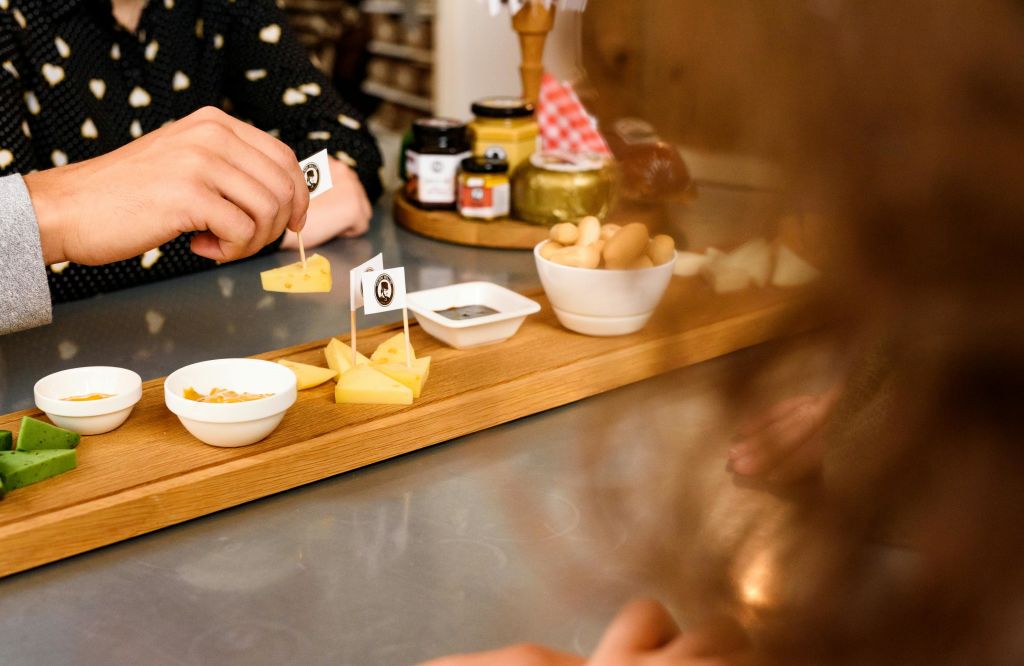조리대에 놓인 치즈 조각, 작은 그릇, 음식이 놓인 나무 쟁반에서 수작업으로 음식을 골라보세요.