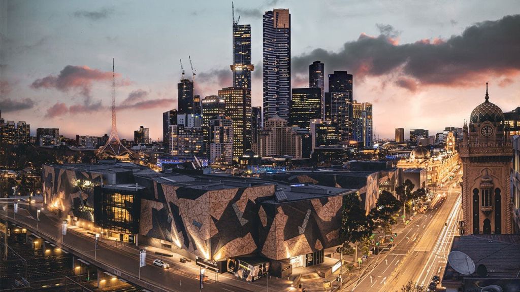 현대적인 건물과 해질 무렵 전경에 기하학적 패턴의 구조가 있는 도시 스카이라인.