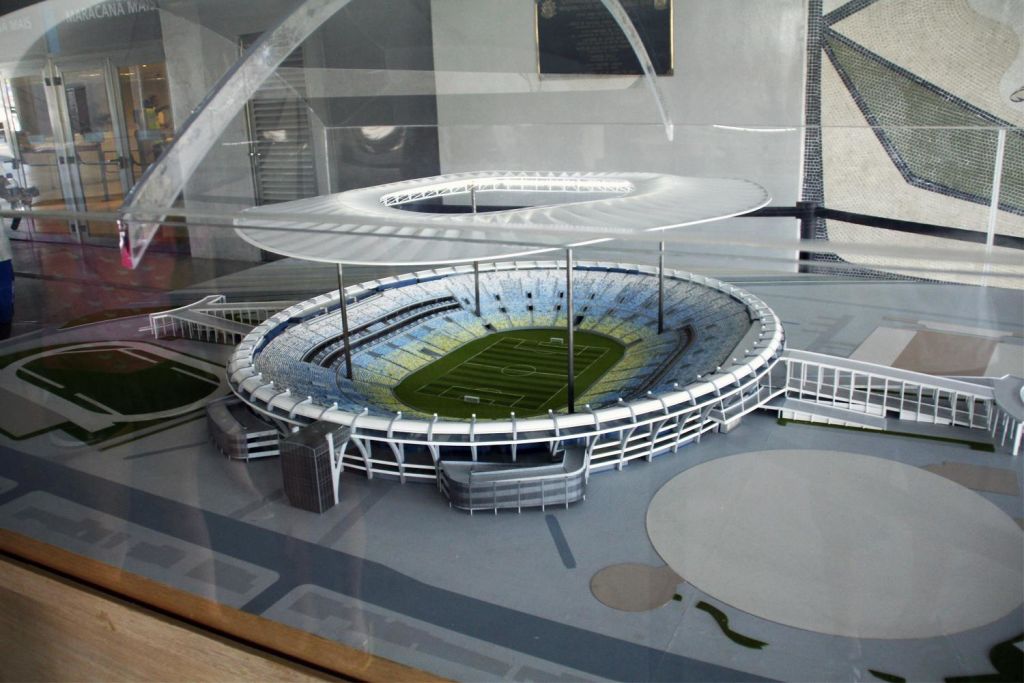 원형 디자인, 계단식 좌석, 대형 캐노피를 갖춘 현대식 경기장의 스케일 모델입니다.