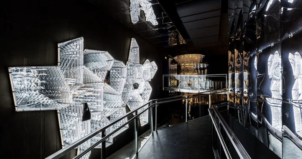 벽에 조명 크리스탈 같은 구조와 반사 표면이 있는 현대적인 인테리어로, 통로가 있습니다.