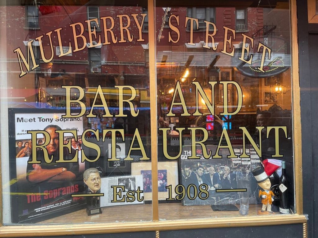 1908년에 설립된 The Sopranos의 기념품을 전시하는 Mulberry Street Bar and Restaurant의 창.