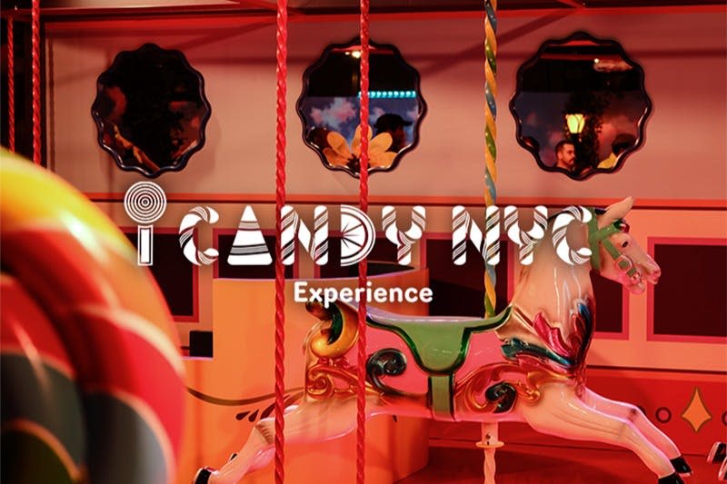 활기찬 놀이 환경을 반영하여 'iCandy NYC Experience' 라는 문구가 겹쳐진 화려한 회전목마입니다.