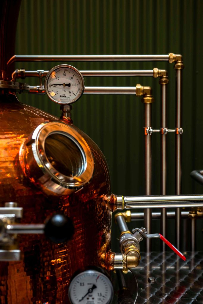 녹색 수직 패널 배경에 게이지와 파이프가 있는 구리.