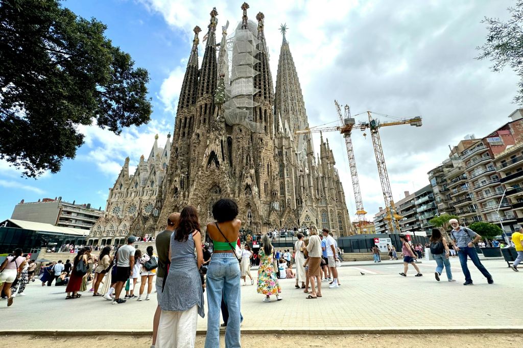 바르셀로나의 사그라다 파밀리아 (Sagrada Familia) 의 복잡한 세부 사항을 관찰하는 여행자 그룹.