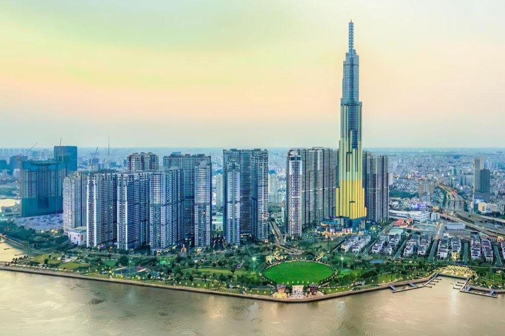 전면에 강이 흐르는 도시 풍경, 중앙에 눈에 띄는 높은 건물을 포함하여 현대적인 고층 건물이 밀집해 있습니다.