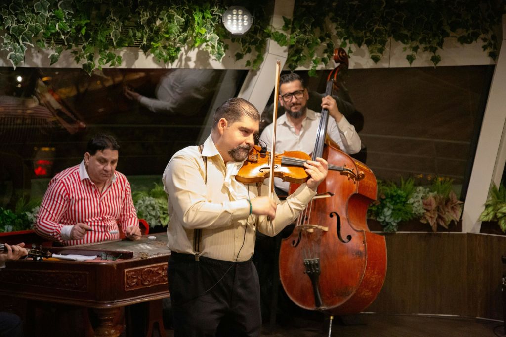 바이올리니스트, 더블 베이시스트, 심발롬 연주자가 출연해 실내에서 연주하는 세 명의 뮤지션.