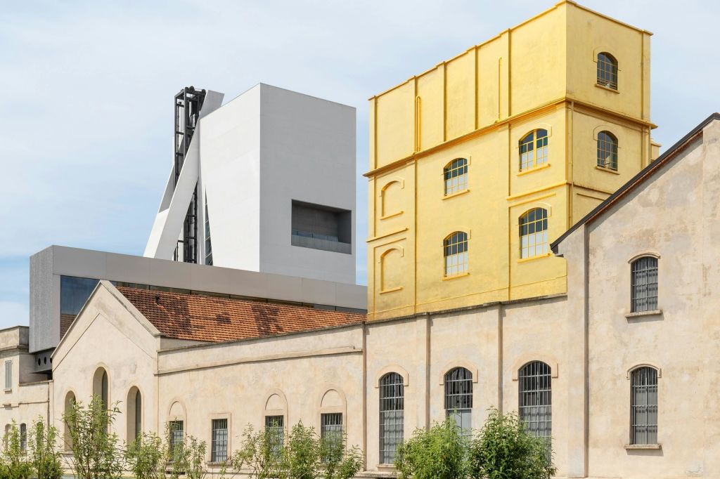 다양한 건축 양식을 갖춘 건물들이 모여 있습니다. 현대적인 흰색 구조와 노란색 클래식 스타일의 외관이 돋보입니다.