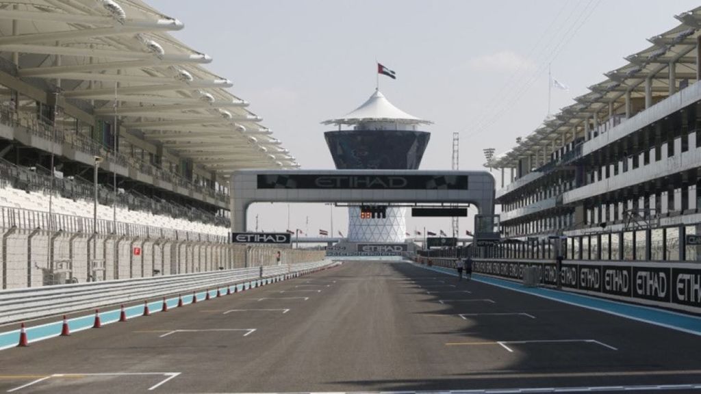 "에티하드" 브랜딩, 컨트롤 타워, UAE 국기가 달린 모터 레이싱 트랙입니다. 스탠드와 피트 레인이 보입니다.
