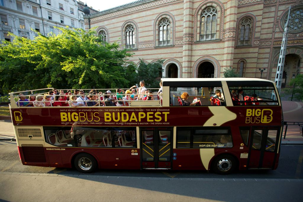 '빅 버스 부다페스트 (Big Bus Budapest)' 라는 이름의 빨간색 2층 투어 버스가 유서 깊은 건물 근처에 주차되어 있습니다.