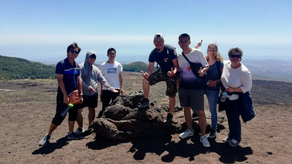 맑은 하늘 아래 바위투성이의 황량한 풍경 속에서 포즈를 취하는 다섯 사람. 등산 장비를 소지하거나 착용하는 경우도 있습니다.
