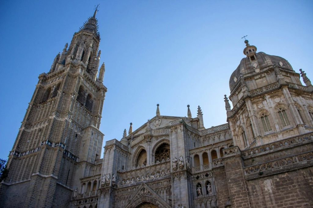맑고 푸른 하늘 아래 화려한 석조 디테일과 높은 첨탑이 있는 유서 깊은 고딕 양식의 대성당입니다.