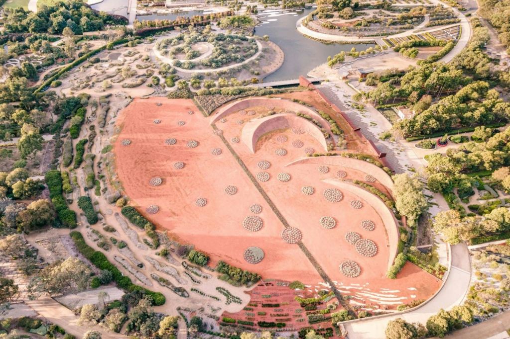 원형의 식물 군집, 구불구불한 통로, 커다란 나선형 구조가 있는 사막 정원의 공중 전망.