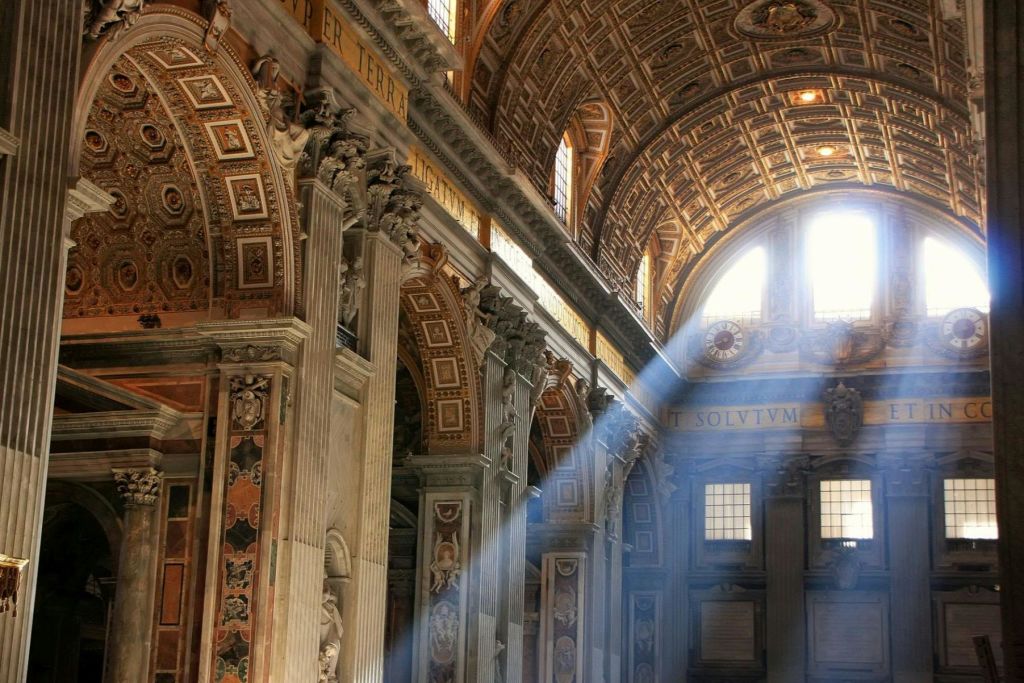 햇살이 화려한 창문을 통해 정교하게 장식된 벽과 아치형 천장을 갖춘 웅장한 인테리어로 흘러갑니다.