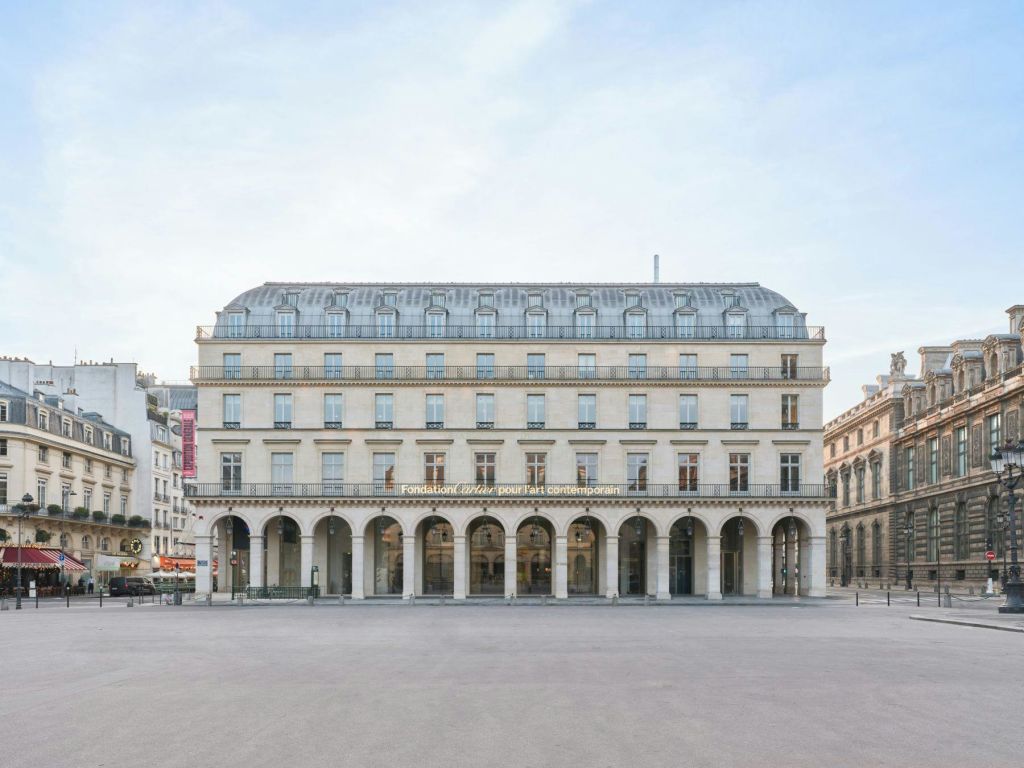 아치형 입구와 "Fondation LVHM pour l 'art contemporain" 이라고 적힌 표지판이 있는 대칭형 건물입니다.