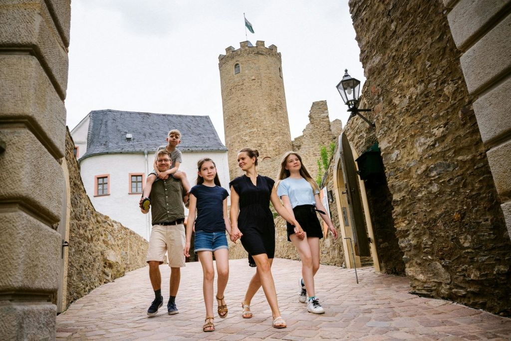 Eine Familie verlässt Burg Scharfenstein durch das Burgtor.