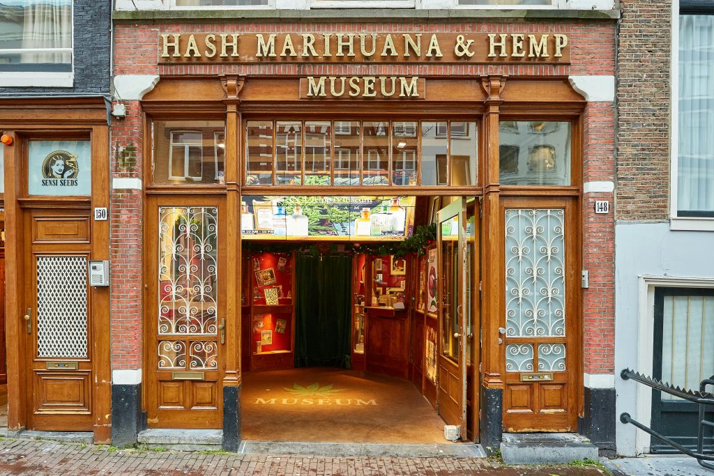 Hash Marihuana & Hemp Museum의 나무 입구에는 장식용 유리 패널이 있으며 내부에 전시품이 전시되어 있습니다.