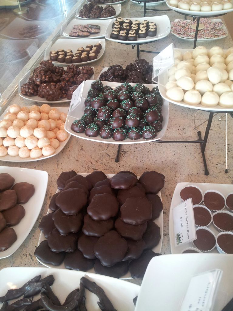 조리대 상단의 흰색 접시에 다양한 초콜릿과 송로버섯이 진열되어 있습니다.