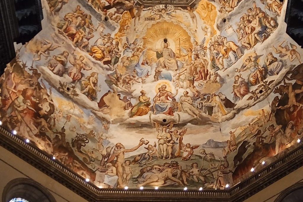 천사들과 구름으로 둘러싸인 빛나는 중심 형상이 있는 역동적이고 천상의 장면에서 수많은 형상을 묘사한 천장 벽화.