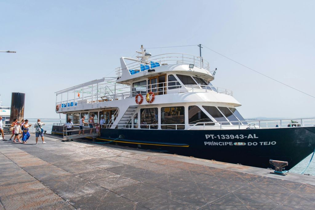 맑은 하늘 아래 부두에서 승객들이 탑승하는 "프린시페 도 테호" 라는 이름의 도킹된 멀티 데크 보트.