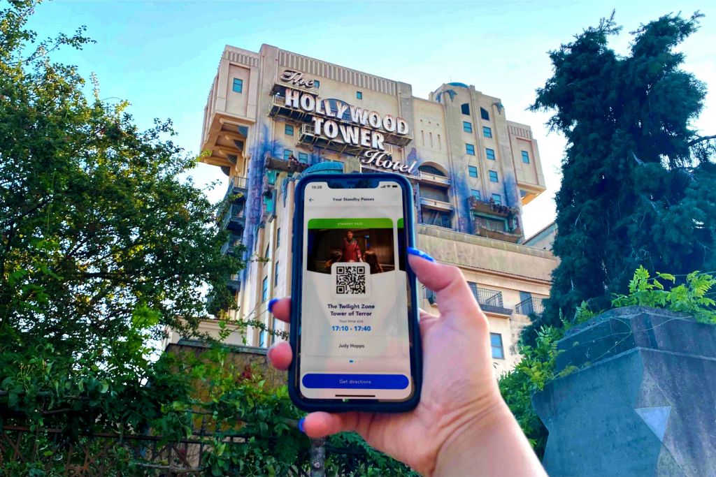 할리우드 타워 호텔 앞에 있는 '트와일라잇 존 타워 오브 테러 (The Twilight Zone Tower of Terror)' 의 출입증을 보여주는 휴대폰을 들고 있는 손.