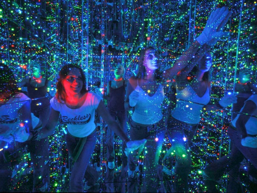 사람들은 반사 표면과 여러 가지 빛깔의 조명으로 가득 찬 방을 탐험하여 생동감 있고 거울 같은 시각 효과를 냅니다.