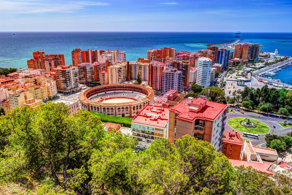 저명한 원형 투우장, 고층 건물, 바다를 배경으로 해안 도시의 공중 전망을 감상할 수 있습니다.
