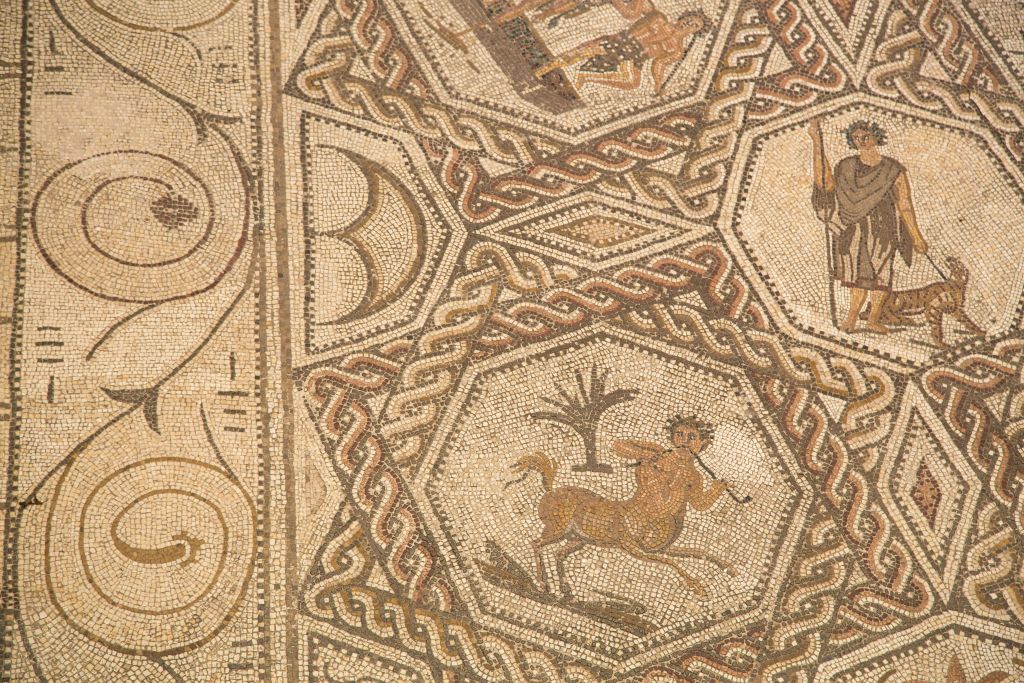 복잡한 기하학적 패턴과 나무 근처의 켄타우로스를 묘사한 중앙 육각형 모양이 특징인 고대 모자이크.