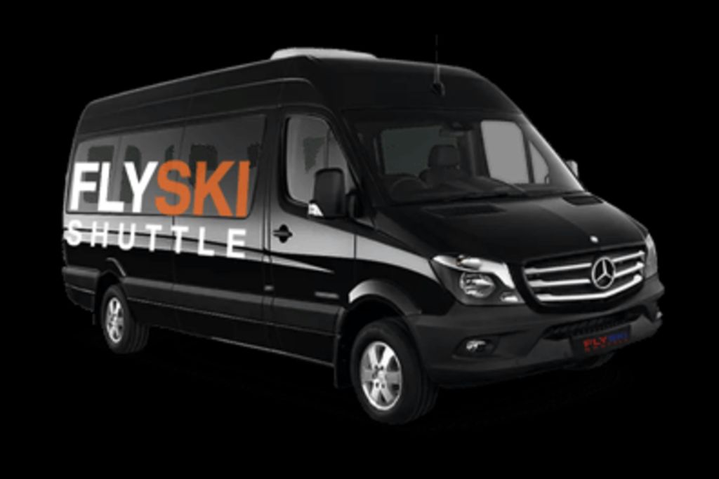 검은색 배경에 표시된 측면에 "Fly Ski Shuttle" 브랜딩이 있는 검은색 셔틀 밴.