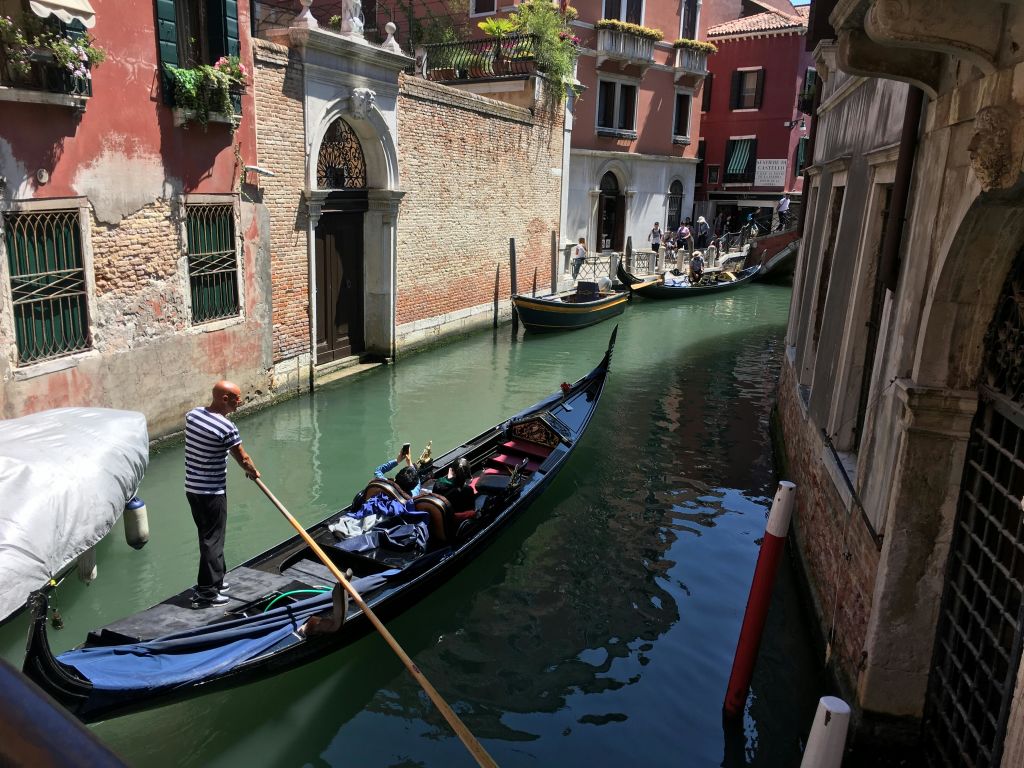 이탈리아 베네치아의 유서 깊은 건물이 늘어선 좁은 운하를 따라 곤돌라를 타고 곤돌라를 즐기며 곤돌라를 배경으로 다른 곤돌라를 만나보세요.