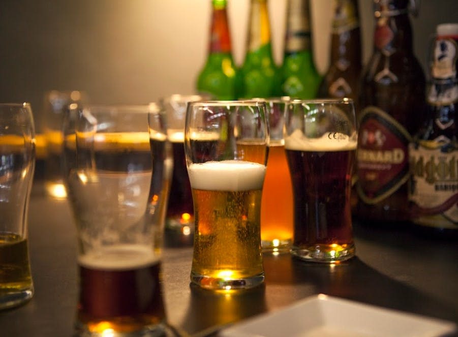 다양한 종류의 맥주와 색상의 맥주가 테이블에 놓여 있습니다.