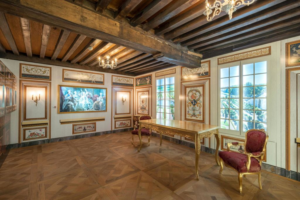 화려한 나무 천장, 샹들리에, 커다란 창문, 금장 테이블, 레드 벨벳 의자, 벽화가 있는 우아한 객실.